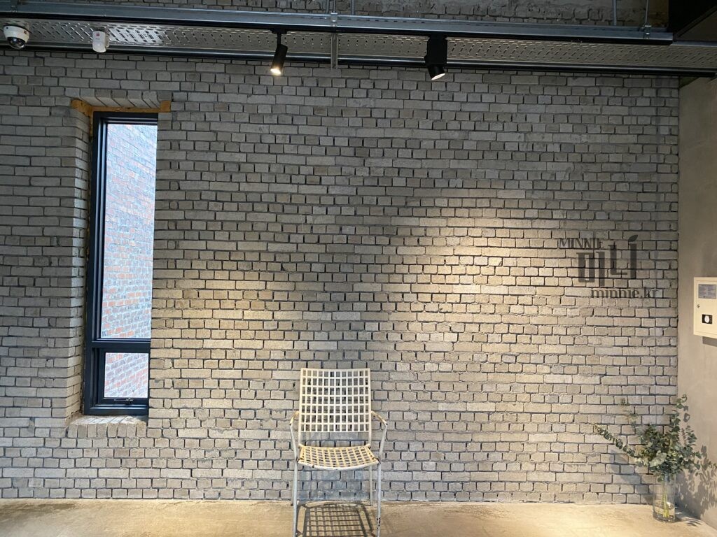 강릉 테라로사 커피 공장 본점 내부의 빈티지한 벽돌 벽과 의자가 있는 감성 포토존