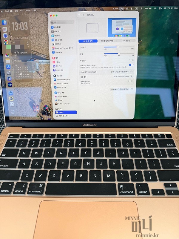 맥북 에어 화면에 시스템 설정의 트랙패드 메뉴가 띄워져 있는 모습과 키보드 전체 샷