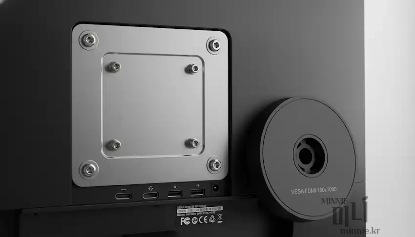 모니터 뒷면의 100x100 VESA 홀 규격과 연결 단자 부위를 상세히 보여주는 클로즈업 사진